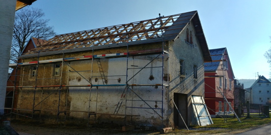 Seitenansicht des ehemaligen Bauernhauses mit abgedecktem Dach